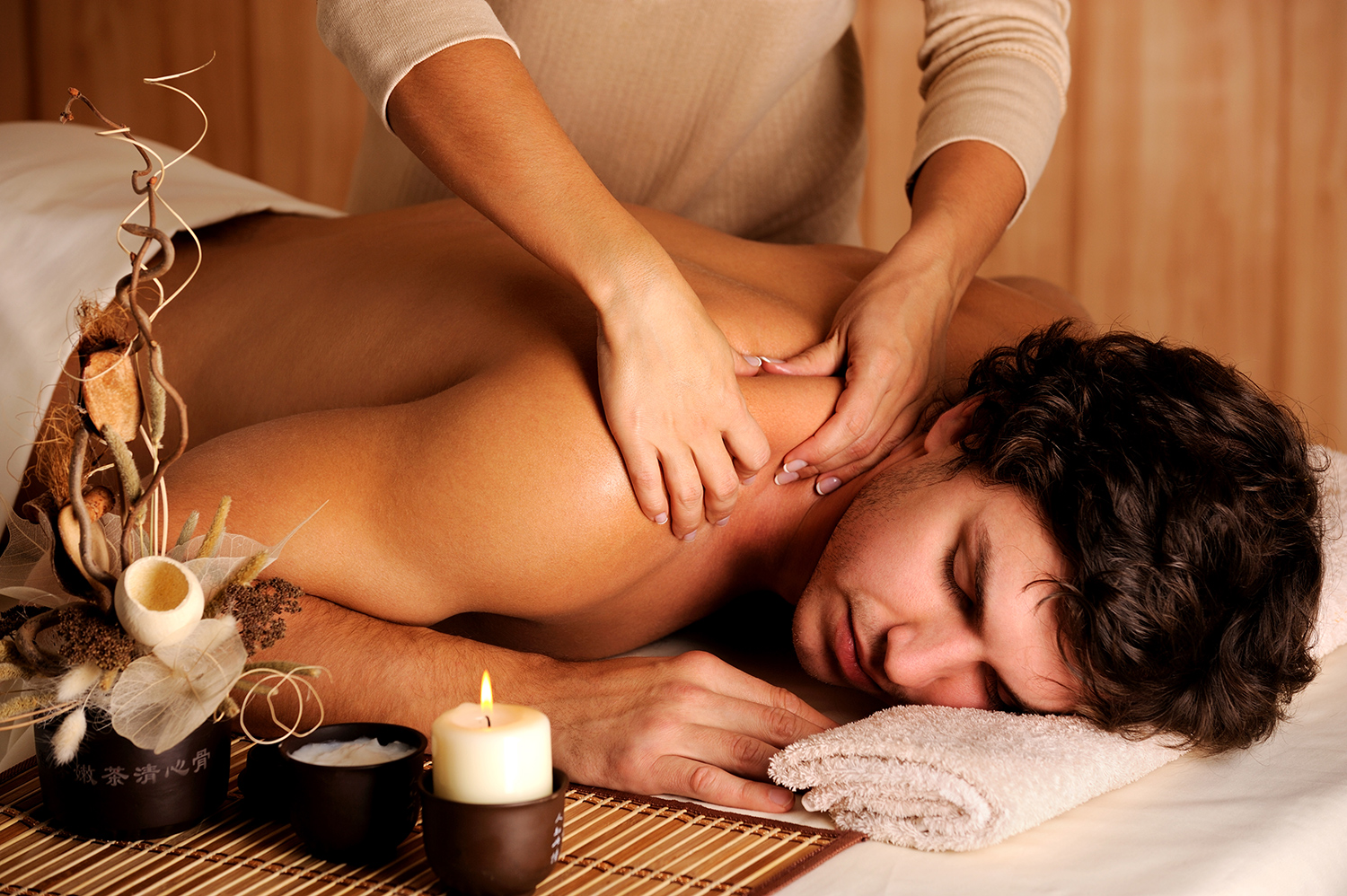Massage therapy with candlelight in a warm spa room